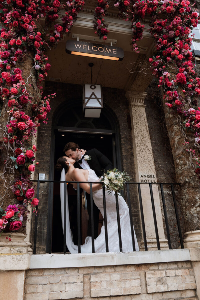 bride and groom embracing in front of The Angel Hotel